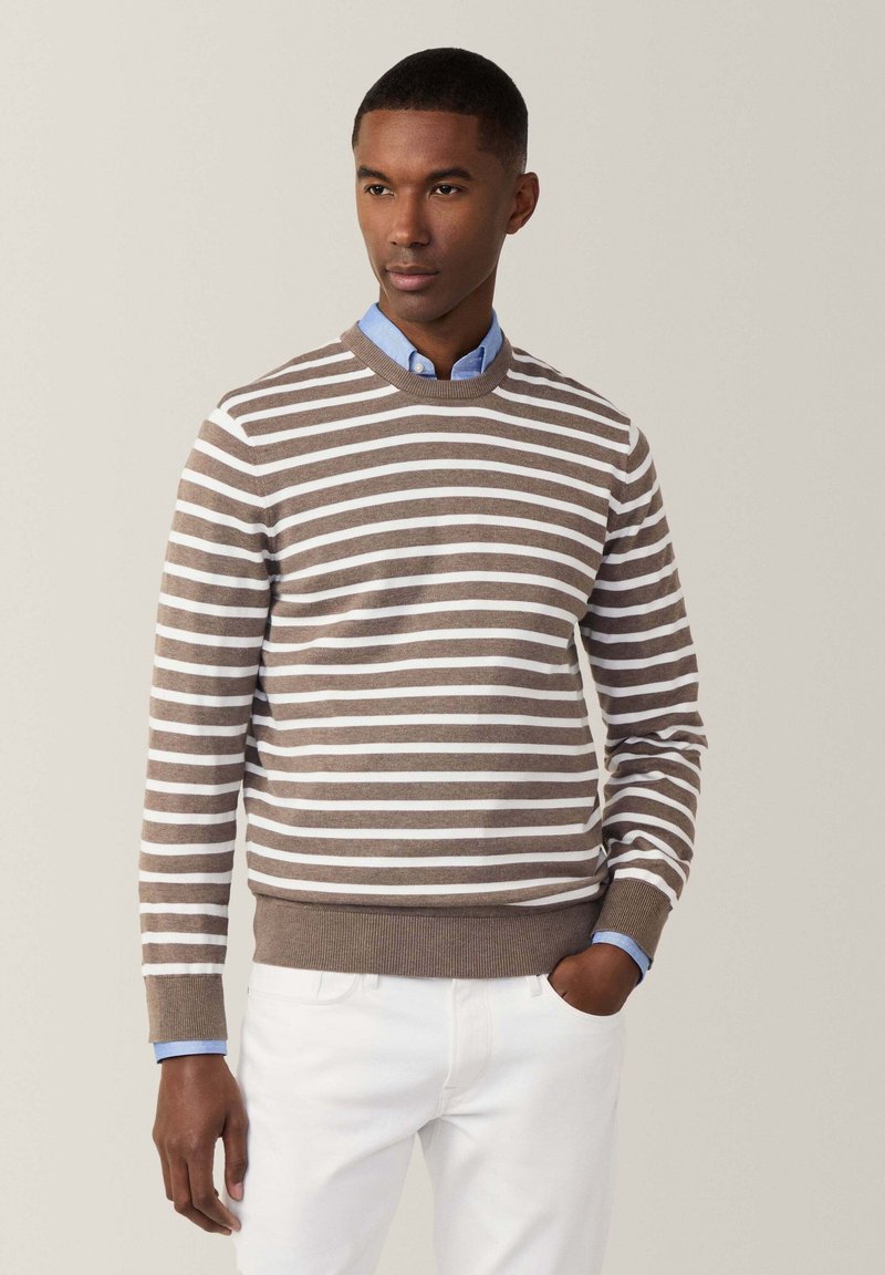 Maglione a righe marroni e bianche, con scollatura rotonda e polsini a coste. Indossato sopra una camicia colletto azzurra, dal taglio slim.