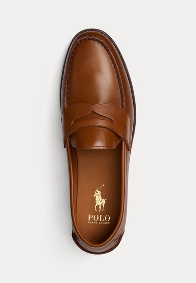 Pantof maro din piele tip penny loafer cu detalii de cusătură și logo Polo Ralph Lauren în interior, pe fundal deschis.