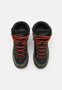 Schwarze und grüne High-Top-Stiefel aus strukturiertem Material, ausgestattet mit orangenen Schnürsenkeln und Gummisohlen. Logo an der Seite sichtbar.