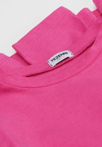 T-shirt en coton fuchsia avec un col rond et des manches courtes, portant une étiquette indiquant "TEZENIS KIDS." Texture lisse.