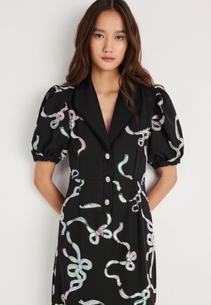 Black dress with puff sleeves and a tailored collar, featuring multicolored, reflective ribbon-like patterns and silver buttons.