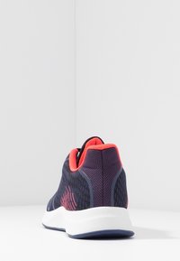 Námořnické síťované sportovní boty s texturovaným povrchem, živě růžovými akcenty na límci a bílou mezipodešví a gumovou podrážkou.