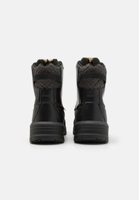 Schwarze wasserdichte Stiefel mit einer strukturierten grauen Innenausstattung, hohem Knöchledesign, verstärktem Absatz und einer robusten schwarzen Gummi-Außensohle.
