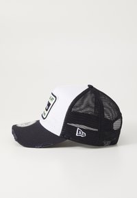 Gorra en blanco y negro con un frente estructurado, parte trasera de malla, visera curva y un parche con texto y gráficos en el frente.