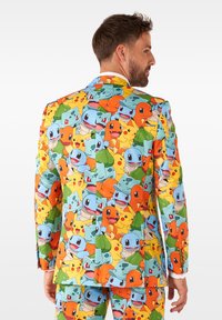 Kleurige jack met een patroon van verschillende cartoonwezens in oranje, geel, groen en blauw, met een gladde stofstructuur en een perfecte pasvorm.