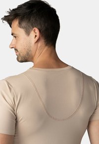 Béžové upnuté tričko s kulatým výstřihem, krátkými rukávy a viditelným plochým švem podél švů. Hladká, elastická látka.