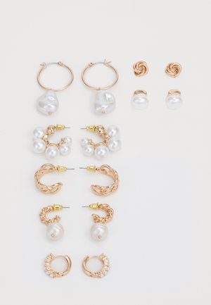 Set of earrings featuring gold-tone metal, various shapes including hoops and studs, adorned with white pearls and twisted designs.