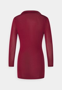 T-shirt de mangas compridas em bordô com gola drapeada, feita de tecido leve, com silhueta ajustada e textura suave.