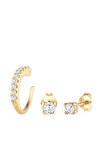Conjunto de pendientes en tono dorado que incluye un aro curvado con piedras preciosas transparentes y dos pendientes de presión con gemas redondas en engaste de garra.