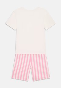 Camiseta de algodón blanca de manga corta con pantalones cortos de algodón a rayas rosas y blancas. El conjunto incluye un diseño simple de cuello redondo.