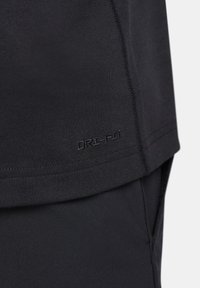 Black Dri-FIT athletic shirt featuring a smooth texture, short sleeves, and a stitched hem with logo detailing on side.