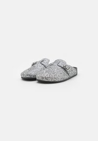 Silberne Glitzer-Slipper mit flacher Sohle, Schnallen-Detail und texturierter Oberfläche mit funkelndem Finish.