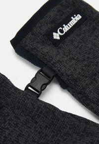 Guantes de punto gris oscuro con un acabado suave y texturizado. Presentan un hebilla de correa negra y una etiqueta de logo blanca en la zona de la muñeca.