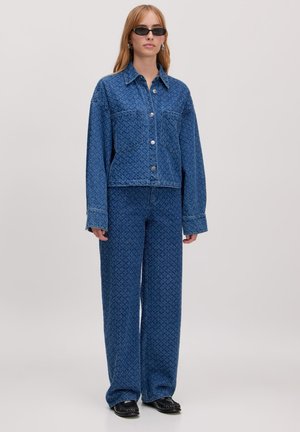 Denimjack en bijpassende wijde broek in het blauw met een gestructureerd patroon; de jack heeft knopen, lange mouwen en twee voorkruiden.