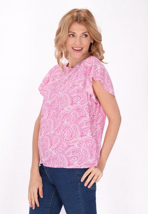 Lyserød paisley bluse med korte flæseærmer, løs pasform og let stof. Sammen med mørke jeans for kontrast.