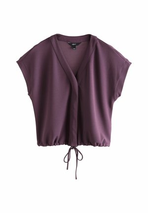Vīna sarkanas krāsas blūze ar apliecama dizainu, īsām piedurknēm un sasienamu jostu viduklī. Izgatavota no gludas auduma, ar brīvu pieguļojumu un dziļu V veida kakla izgriezumu.