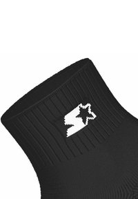 Sort strikket strømpe med ribbet design og en fremtrædende hvid stjerne-logo på siden. Ingen yderligere mønstre eller teksturer synlige.