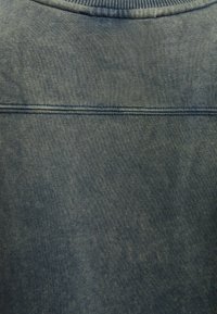 Sudadera azul oscura con un cuello redondo acanalado, textura suave y un sutil patrón jaspeado, con una costura recta en la parte trasera.