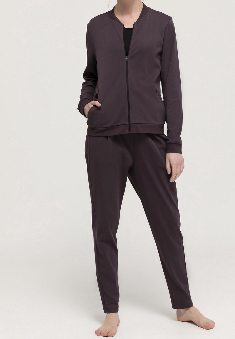 Mörklila träningsset bestående av en zip-up jacka med rund halsringning och långa ärmar, i kombination med matchande avsmalnande byxor.