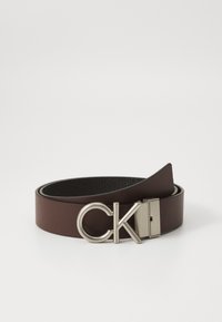 Brown leather belt with a smooth finish, featuring a silver metal buckle embossed with "CK." The design includes a classic, minimalist style.
