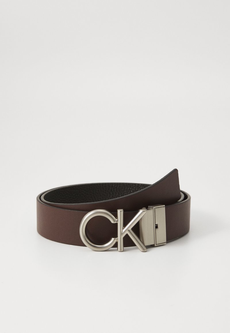 Brown leather belt with a smooth finish, featuring a silver metal buckle embossed with "CK." The design includes a classic, minimalist style.