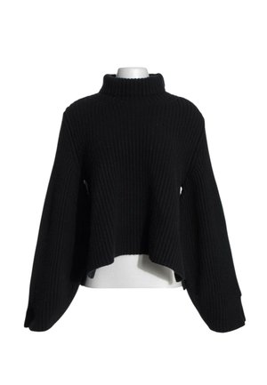 Jersey negro de punto acanalado con cuello alto, mangas largas y anchas, y dobladillo asimétrico sobre un torso de maniquí blanco.