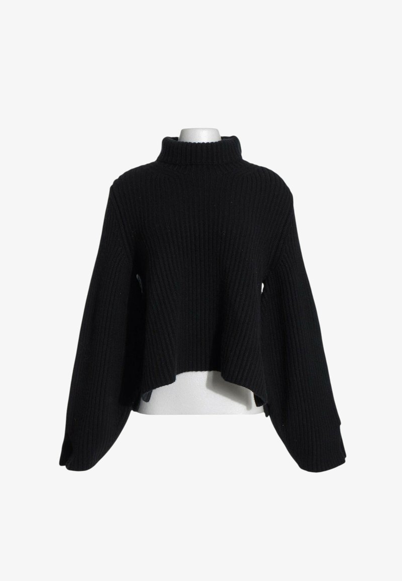 Pull en maille côtelée noire avec col montant, manches longues évasées et ourlet asymétrique sur un buste de mannequin blanc.