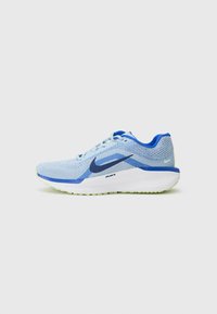 Zapatilla deportiva de color azul claro con parte superior de malla, acentos en color marino y suela blanca. Cuenta con una suela acolchada y un sistema de cordones para un ajuste seguro.