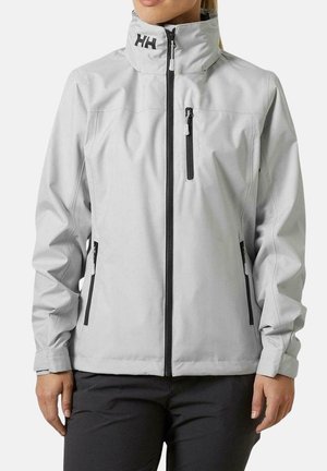 Chaqueta impermeable de un gris claro con un cuello alto, cremalleras negras y dos bolsillos laterales. Presenta un logo en el cuello y un diseño elegante y ajustado.