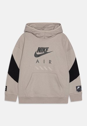 Sudadera Nike de color gris claro con acentos en negro, un bolsillo frontal y un logo impreso. Cuenta con capucha con cordón y tejido suave y texturizado.
