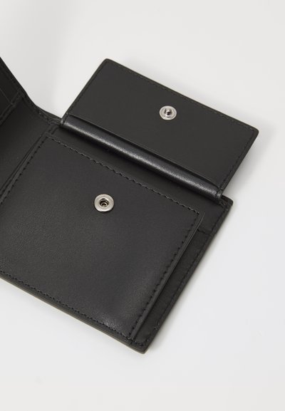 Black leather wallet interior with two card slots and a snap closure. Smooth texture with stitched edges and a metallic snap detail.