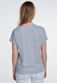 T-shirt gris à manches courtes avec un col rond et des ourlets roulés, en tissu doux, vu de dos. Design simple sans motifs.