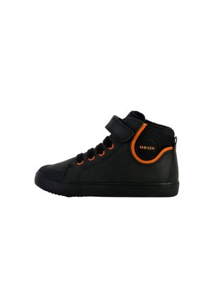 Zapatillas altas negras de material sintético con acentos naranjas, que cuentan con una correa de Velcro, puntera redonda y suela de goma texturizada.