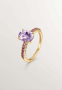 Anillo de oro con una gema ovalada lavanda en el centro, acentuada por piedras rosas a lo largo de la banda texturizada. Diseño elegante y único.