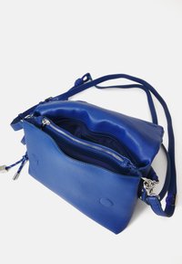 Borsa crossbody in pelle blu con finitura testurizzata, dotata di chiusura con zip, tasche interne e una lunga tracolla regolabile.