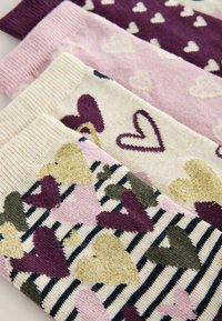 Farebné vzorované ponožky s rôznymi srdcami v purpurovej, ružovej a zlatej farbe na krémovom pozadí, s pruhovanými a jednoliatymi časťami.