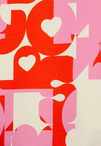 Abstraktní vzor s velkými červenými a růžovými tvary, včetně srdcí a geometrických útvarů, na krémovém pozadí.