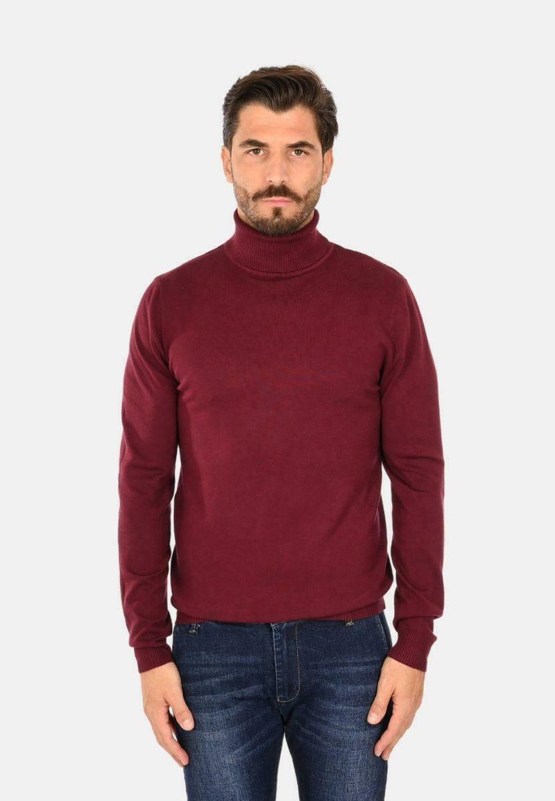 Maglione a collo alto bordeaux realizzato in morbidissimo tessuto a maglia, con maniche lunghe e orlo e polsini a coste, abbinato a un paio di jeans in denim blu.