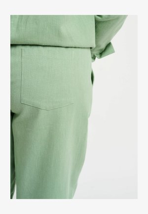 Svijetlozelene hlače od teksturirane tkanine, s leđnim džepom s šiljastim poklopcem. Jednostavan dizajn, bez vidljivih kopči ili ukrasa.