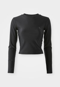 Sort langærmet tætsiddende crop top med rund hals og subtilt logo på brystet, præsenteret på en ensfarvet lys baggrund.