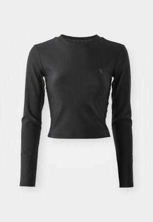 Mustamoodne pika varrukaga pehme kropp-särgid, millel on ümmargune kaelus ja tagasihoidlik logo rinnal, esitatud heleda ühtlase taustaga.