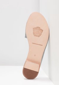 Szare zamszowe buty z jasną skórzaną podeszwą. Posiadają wytłoczone logo oraz rozmiar "37". Okrągły przód z gładkim wykończeniem.