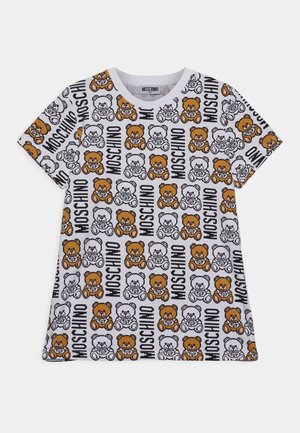 Biały T-shirt z krótkim rękawem z wzorem w całej powierzchni przedstawiającym brązowe i białe misie oraz czarny napis "MOSCHINO" ułożony w pionowe paski.
