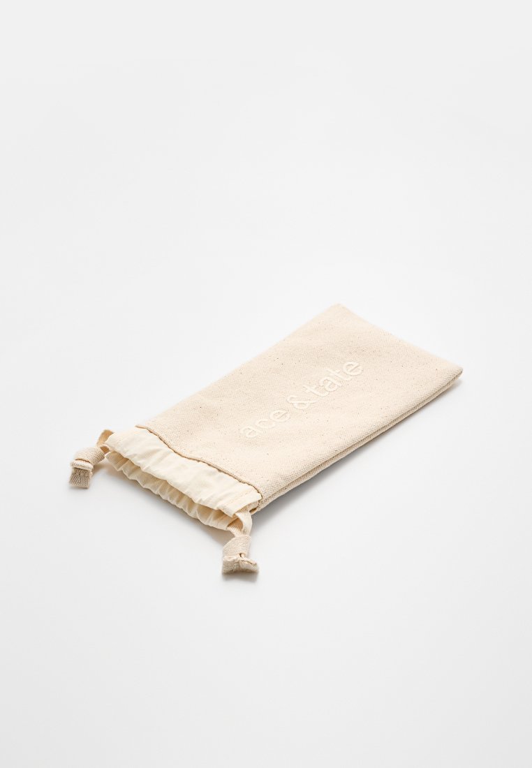 Beige Stoffbeutel mit Kordelzug und dem aufgestickten Schriftzug "aerie & tale", flach auf einem weißen Hintergrund liegend.