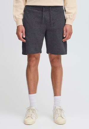 Shorts de sport gris foncé, mi-cuisse, en tissu doux avec une taille élastique et un cordon de serrage. Offre une coupe décontractée et sans poches visibles.