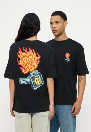 Két személy fekete pólót visel, amelyen lángoló öngyújtó grafika látható; az egyik hátulról, a másik elölről néz.