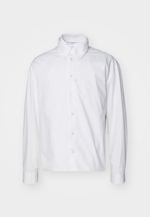 Camisa blanca de manga larga, con botones, hecha de algodón. Presenta un cuello clásico, cierre frontal con botones y puños enrollados con una textura suave.