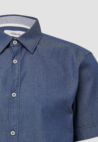 Camicia corta navy con colletto button-down, caratterizzata da un sottile motivo a righe e dettagli interni blu chiaro. Quattro bottoni sul davanti.