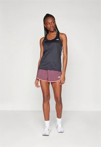 Top desportivo preto com design de costas estilo racerback, combinado com calções bordô com um acabamento rosa em contraste, adequado para atividades desportivas.