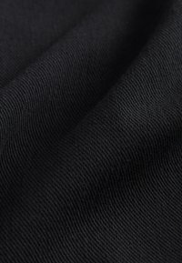 Schwarzer Textilstoff mit glatter, gewebter Textur, der diagonale Rippen und einen weichen Glanz zeigt. Das Material wirkt strapazierfähig und flexibel.